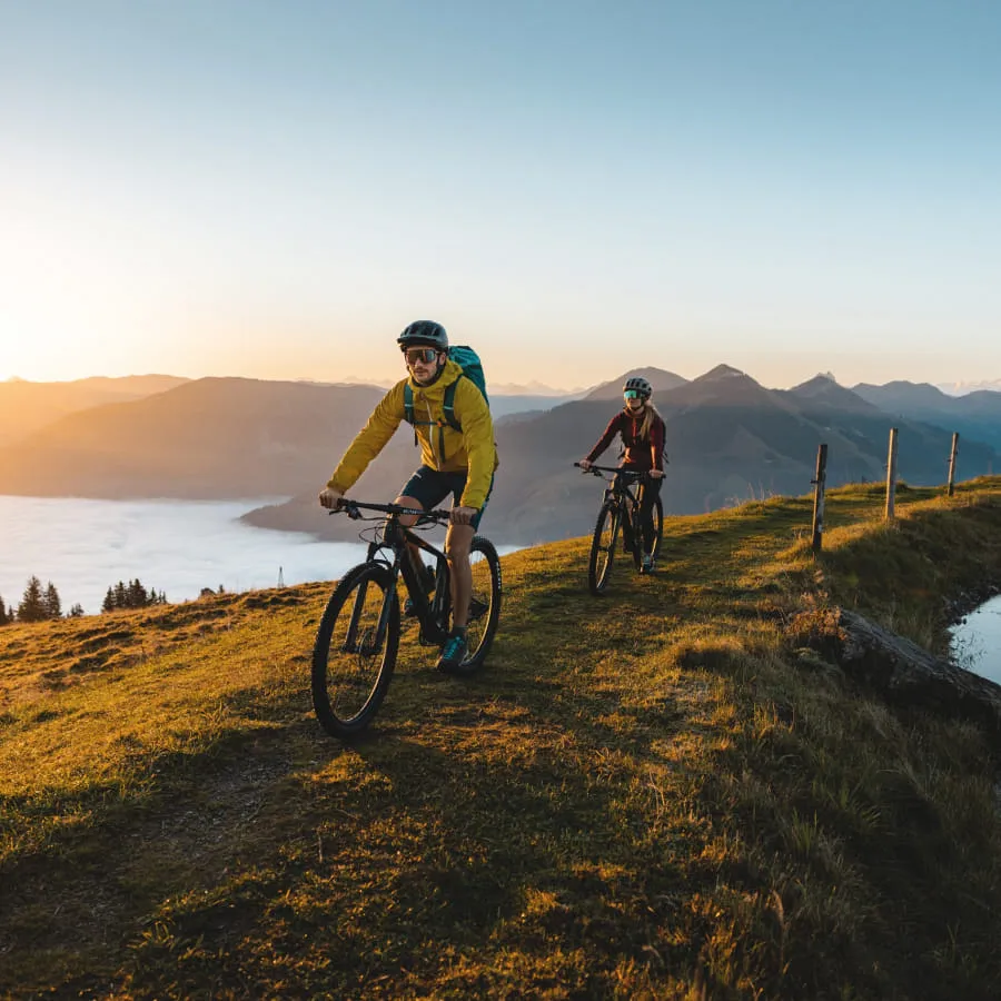 Zwei Radfahrer fahren entlang eines Weges über dem See im Brixental.