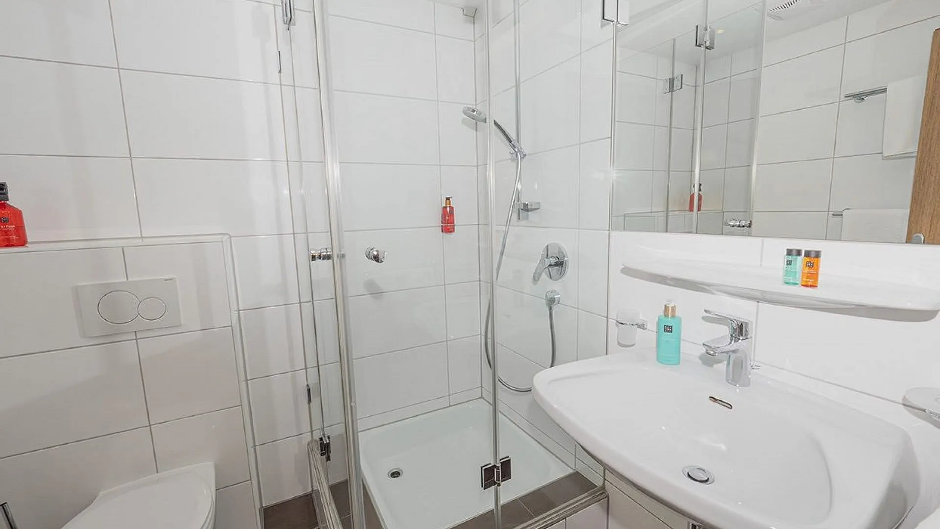Modernes Badezimmer mit Dusche, Waschbecken und Toilette.