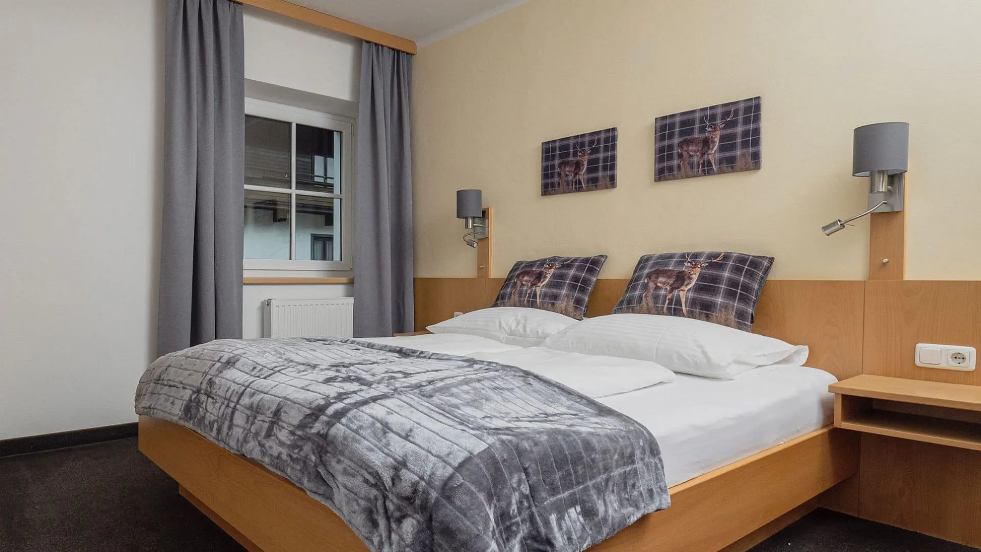 Schlafzimmer mit Doppelbett, Fenstern und Bildern an der Wand