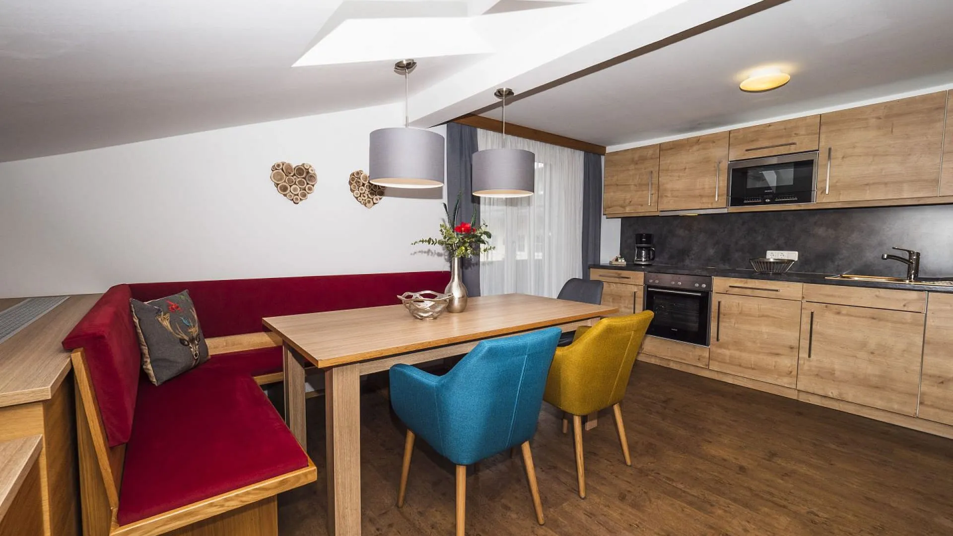 Moderne Küche und Essbereich mit Holz Möbeln und bunten Stühlen