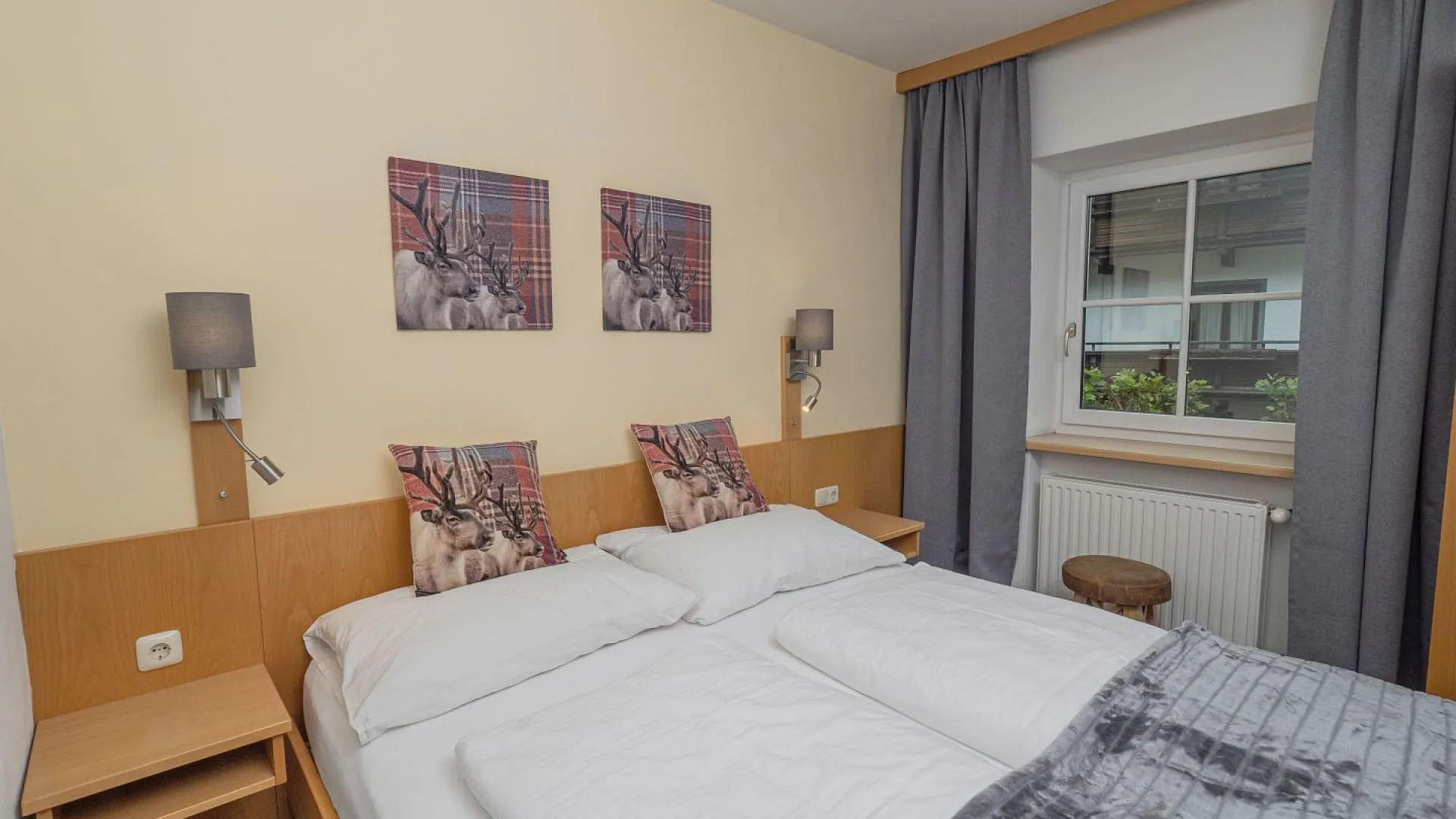 Helles Schlafzimmer mit Doppelbett und Bildern an der Wand