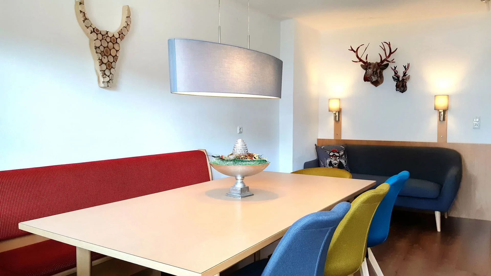 Essbereich mit einem roten Sofa, einem blauen Sofa und einem Tisch.