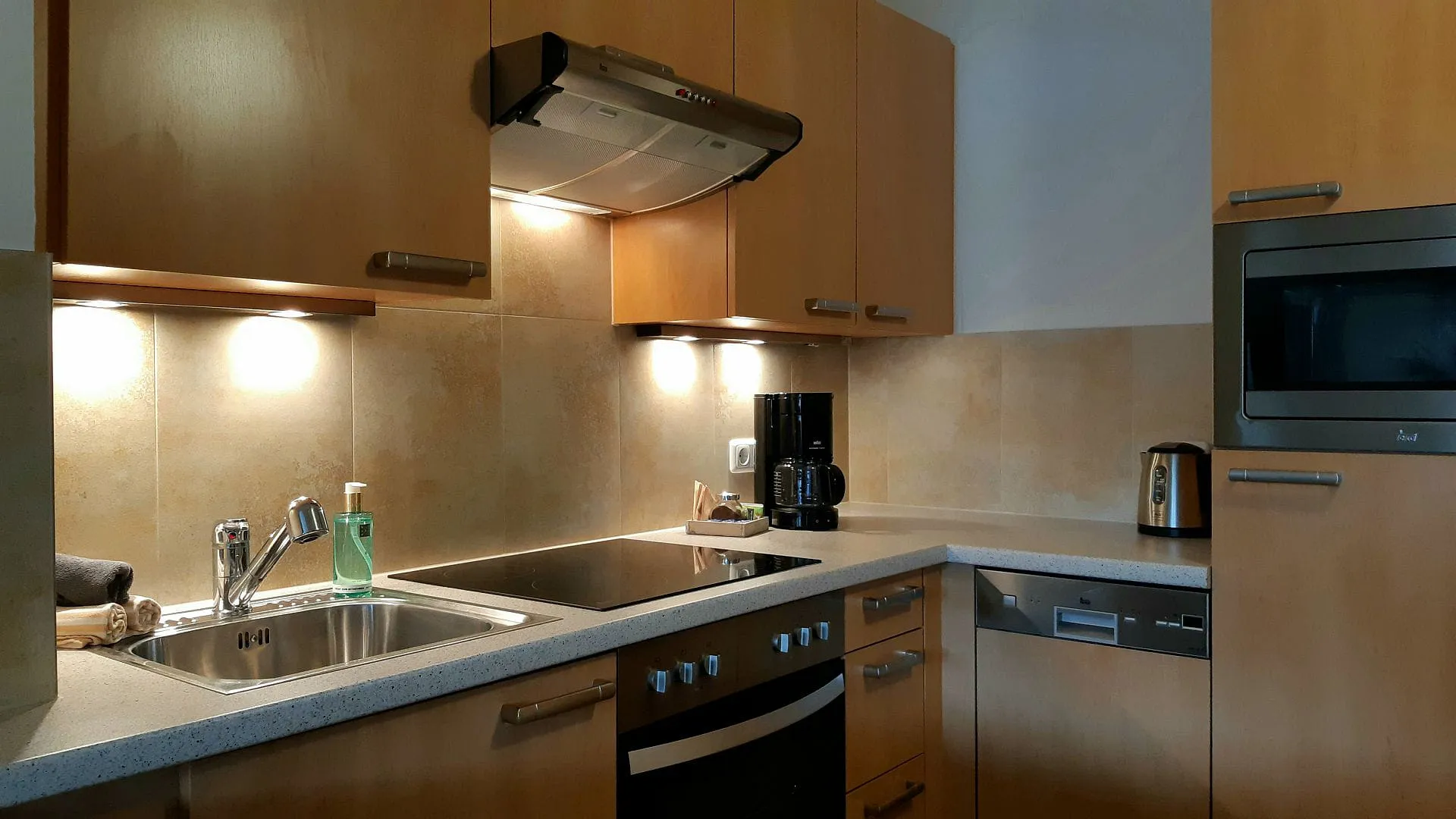 Moderne Küche mit Holzmöbeln, Arbeitsflächen und Geräten